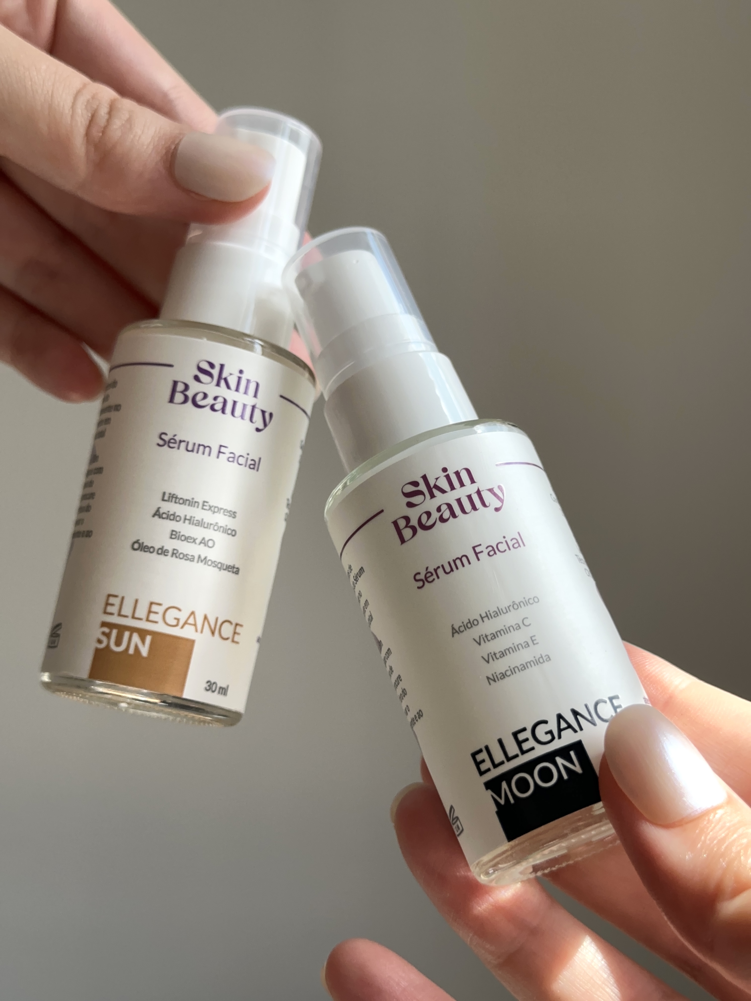 Dois sérum faciais Skin Beauty: Ellegance Sun (frasco dourado, uso diurno) e Ellegance Moon (frasco azul, uso noturno), exibidos ao lado de suas respectivas embalagens